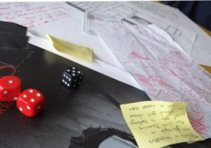 Crumpled up papers and post-its and dice