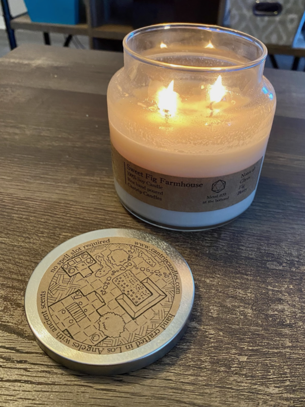 Sweet Farmhouse Fig Candle lit with cover next to it