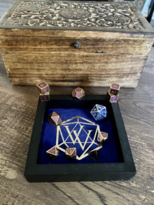 Blue dice tray with purple and gold metal dice and one large blue and silver metal dice