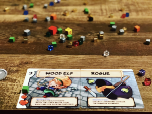 Race and Class card read Wood Elf and Rogue with cubes scattered in the background