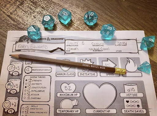 Dungeons and Dragons modified character sheet with set of blue polyhedral dice