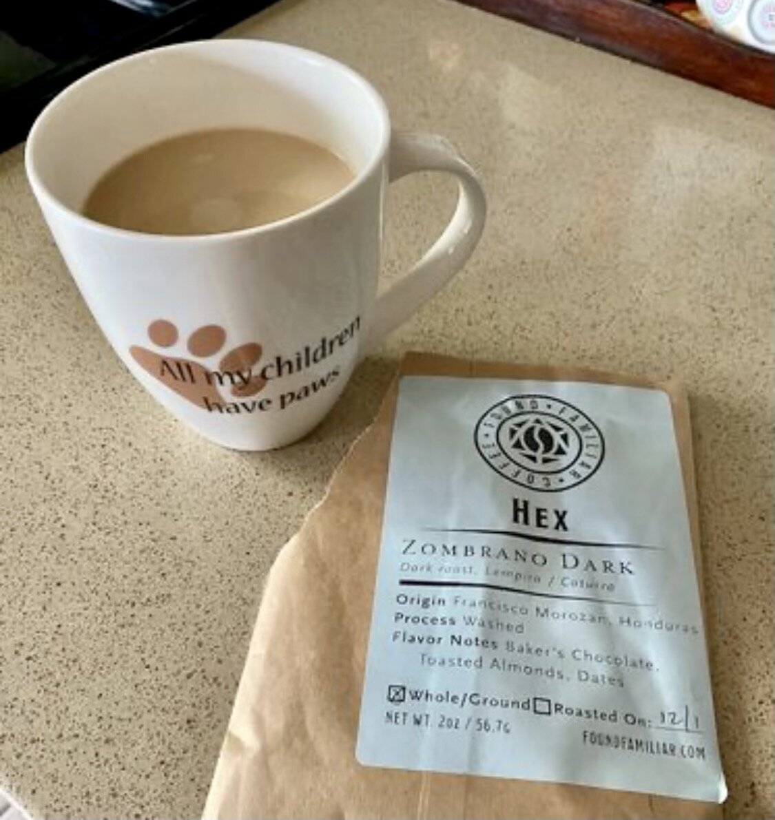 coffee cup next to a sample size bag of Hex