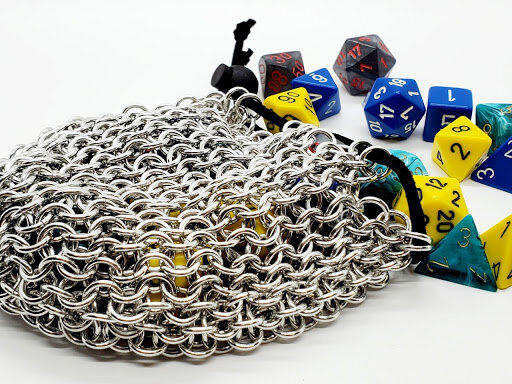 Chainmaille dice bag with dice spilling out of the top