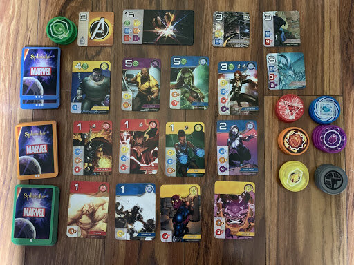 The layout for Splendor through the mobile game format. There are three rows of cards in the main area, six rows of colored tokens, and three different noble cards.