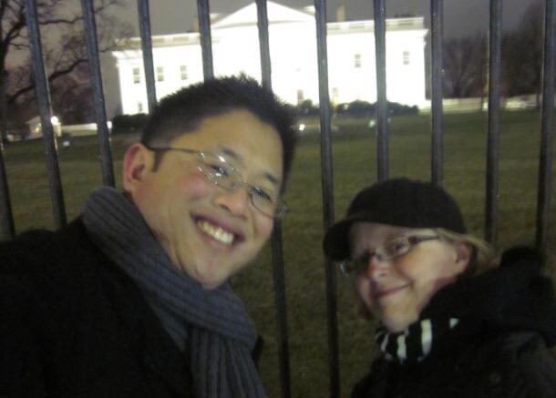 Two people in front of white house