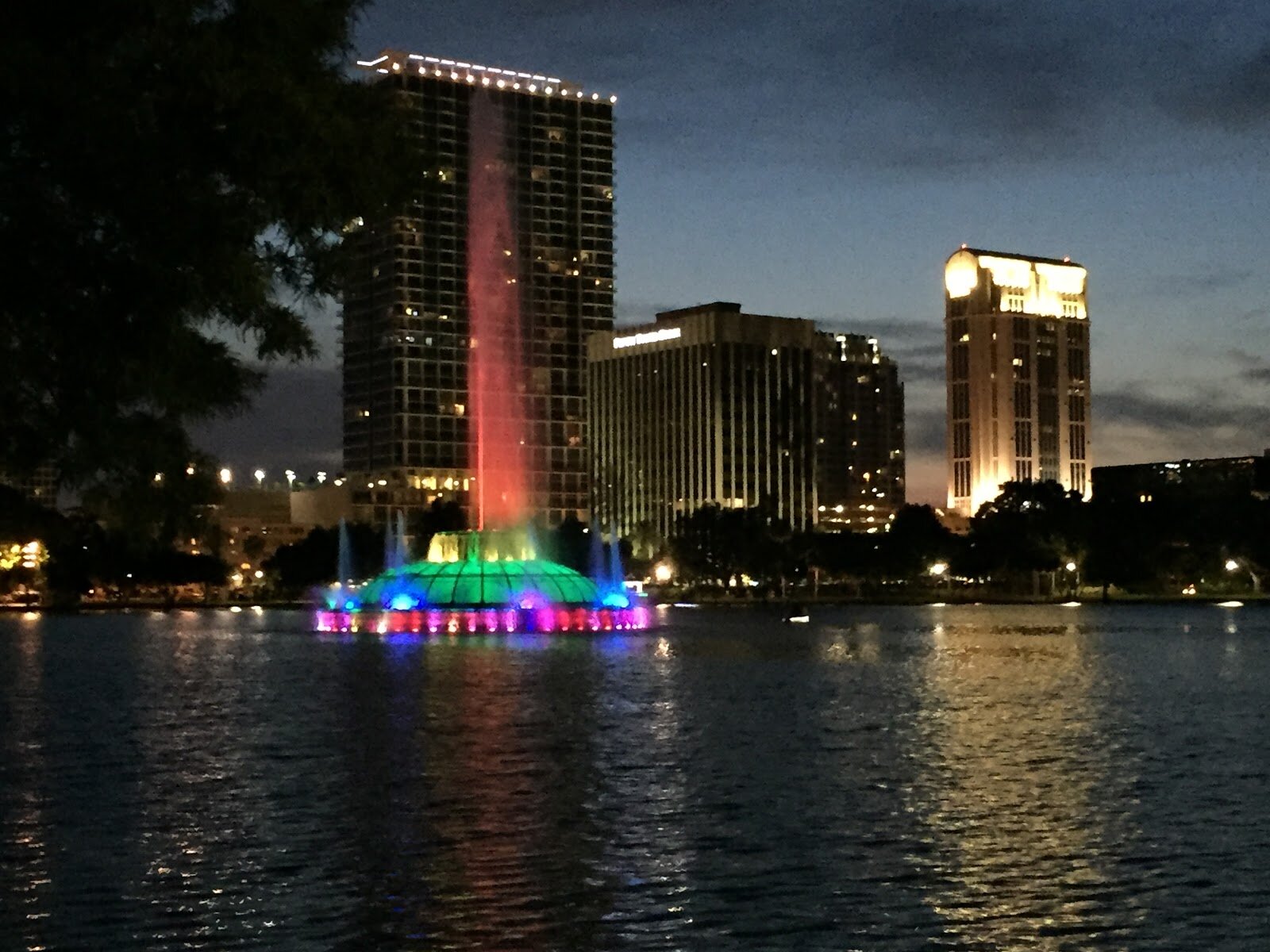 Photo description: Downtown Orlando with the iconic Lake Eola fountain lit up as a rainbow in honor of those lost by the Pulse tragedies.