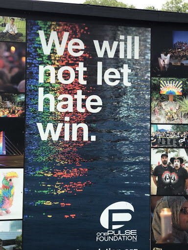 Photo Description: The Phrase “We will not let hate win.” over water reflecting the colors of the rainbow. Photo credit: Allison J. Walker, taken at the interim Pulse Memorial in Orlando, FL