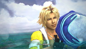 Lightskinned man with blonde hair in a yellow jacket holding a blue ball