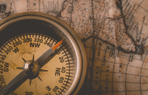 Close up of a compass on a worn map