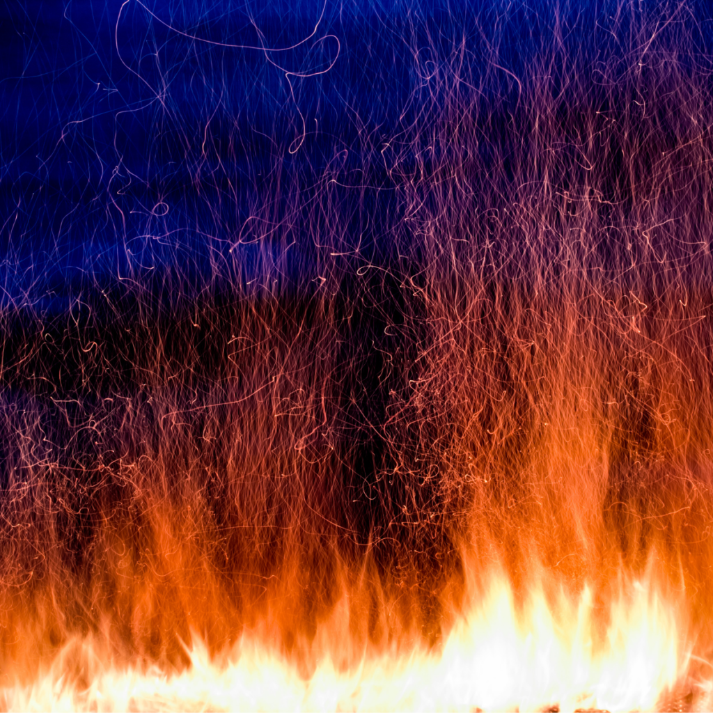 Close up of orange fire on a blue forest