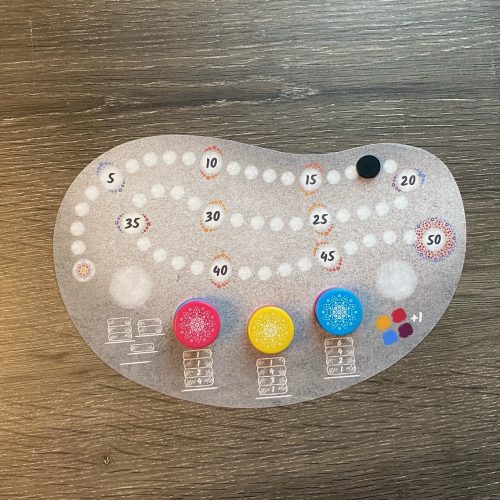 Mandala Stones Player Score Tracker with multicolored tiles on it.